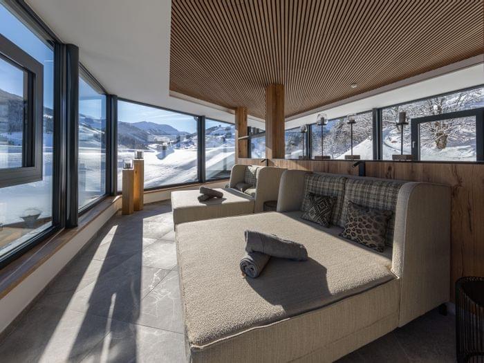 Badehaus Ruheraum mit Großen Liegen und Panoramafenster mit Ausblick auf die Winterlandschaft 