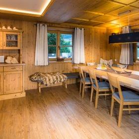 Cozy alpine dining room with wooden furniture, bench seating and warm lighting
