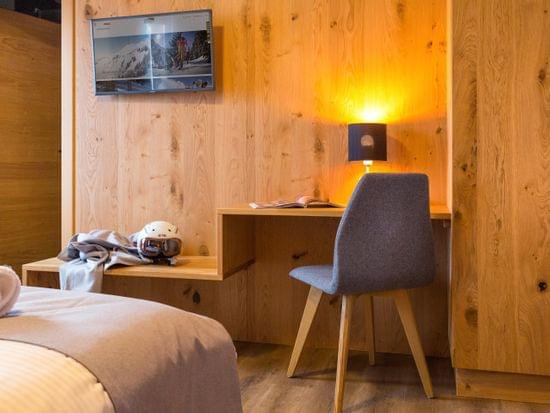 Schlafzimmer mit Sitzmöglichkeit und TV an Wand 