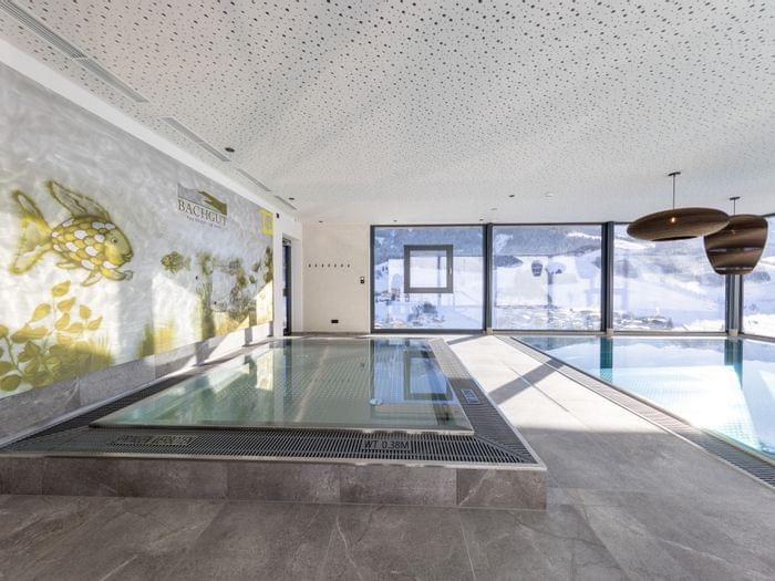 The kids’ area in the bathhouse, featuring a children’s pool with fish on the wall and views of the snow-covered mountains.