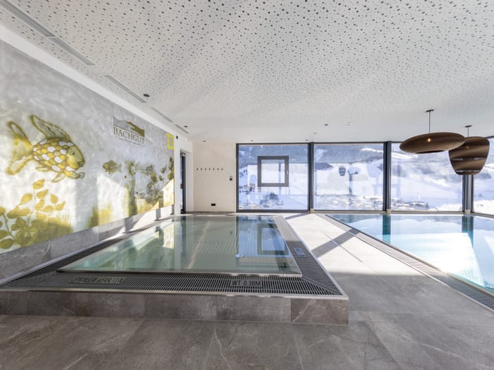 The kids’ area in the bathhouse, featuring a children’s pool with fish on the wall and views of the snow-covered mountains.