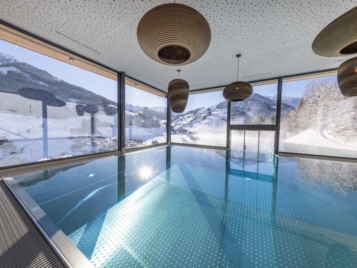 The Bachgut bathhouse indoor pool with a view of the winter landscape.