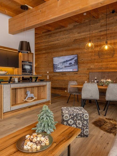 Cozy alpine apartment with modern kitchen, wooden decor, dining area and holiday decorations