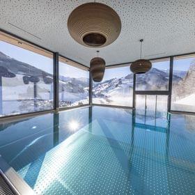 The Bachgut bathhouse indoor pool with a view of the winter landscape.