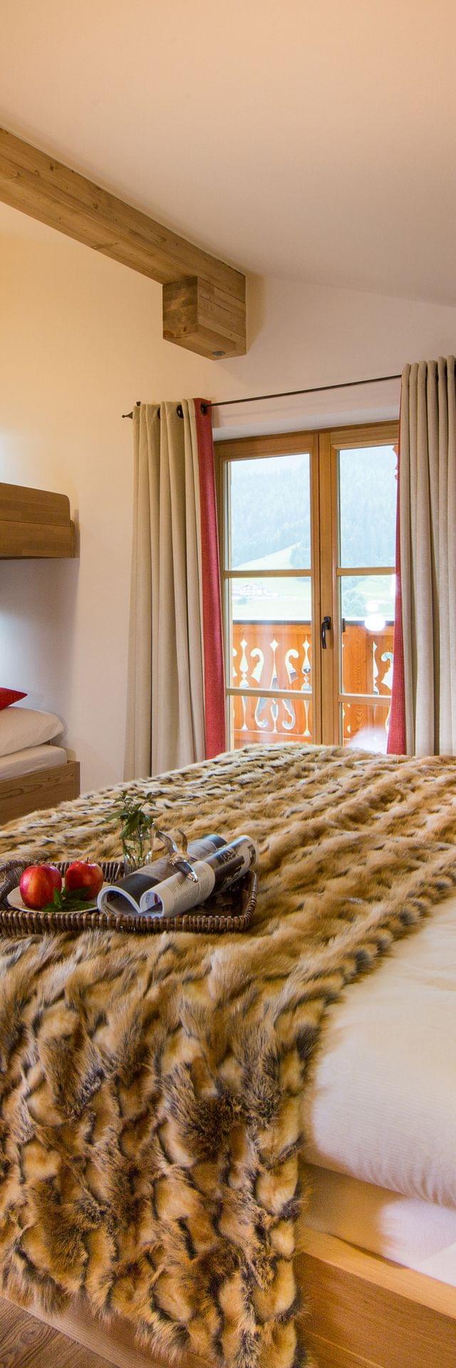 Zimmer mit Doppelbett und Stockbett, Hochwertig mit Holz verkleidet, Rote Akzente und in Alpinem Chic 