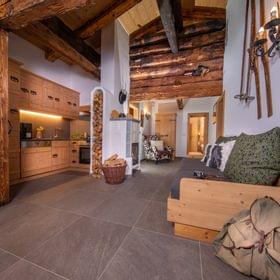 Gemütliches Alpen-Wohnzimmer mit rustikalen Holzmöbeln, kleiner Küche und Kamin