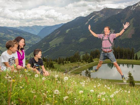 Glückliche Familie wandert in den Alpen mit Bergblick und See im Hintergrund
