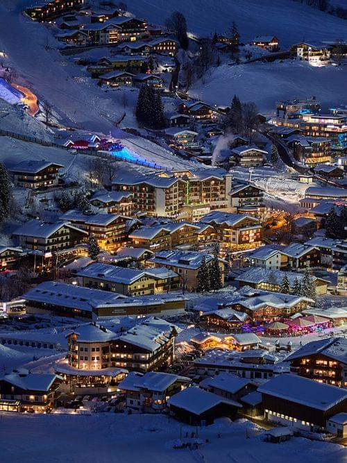 Snow-covered alpine village illuminated at night in winter ski resort