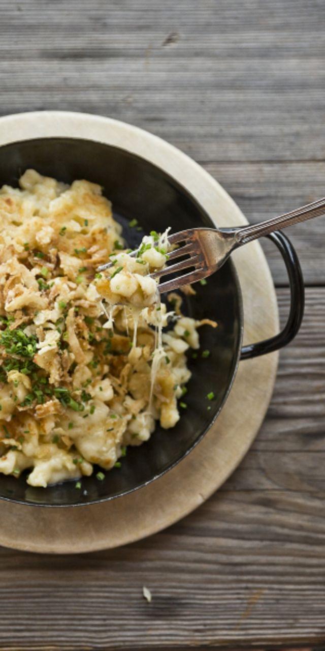 Käsespätzle mit Röstzwiebeln in einer Pfanne und Beilagensalat