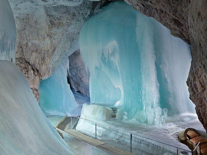 Massive ice formations inside a natural limestone cave with a wooden walkway