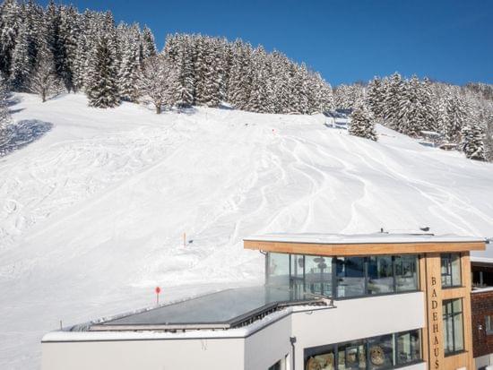 Vogelperspektive vom Bachgut mit dem Badehaus und Invinity Pool, Winterlich verschneit und Sonnenschein 