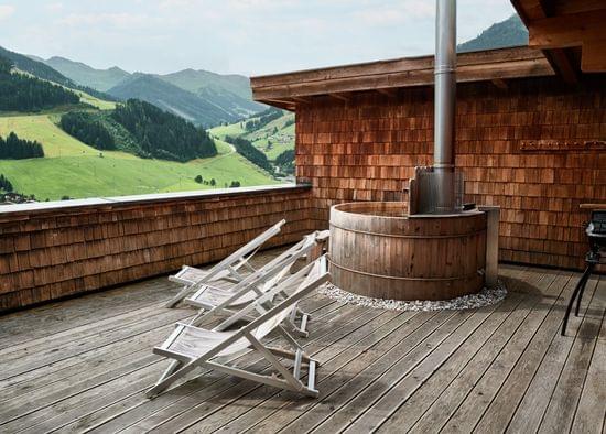 Holz-Dachterrasse mit Whirlpool, Liegestühlen und Bergblick