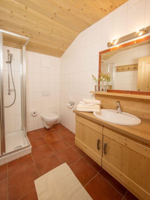 Modernes rustikales Badezimmer mit Holzwaschbecken, Dusche und weißen Fliesenwänden