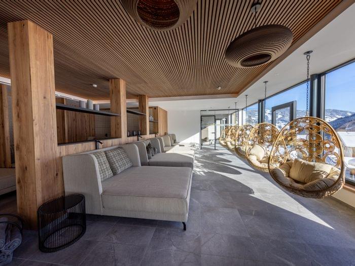 Badehaus Ruheraum mit Großen Liegen und Panoramafenster mit Ausblick auf die Winterlandschaft 