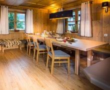 Cozy wooden alpine dining room with rustic furniture and natural lighting