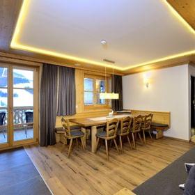 Cozy alpine chalet dining and living area with wooden furniture and mountain view