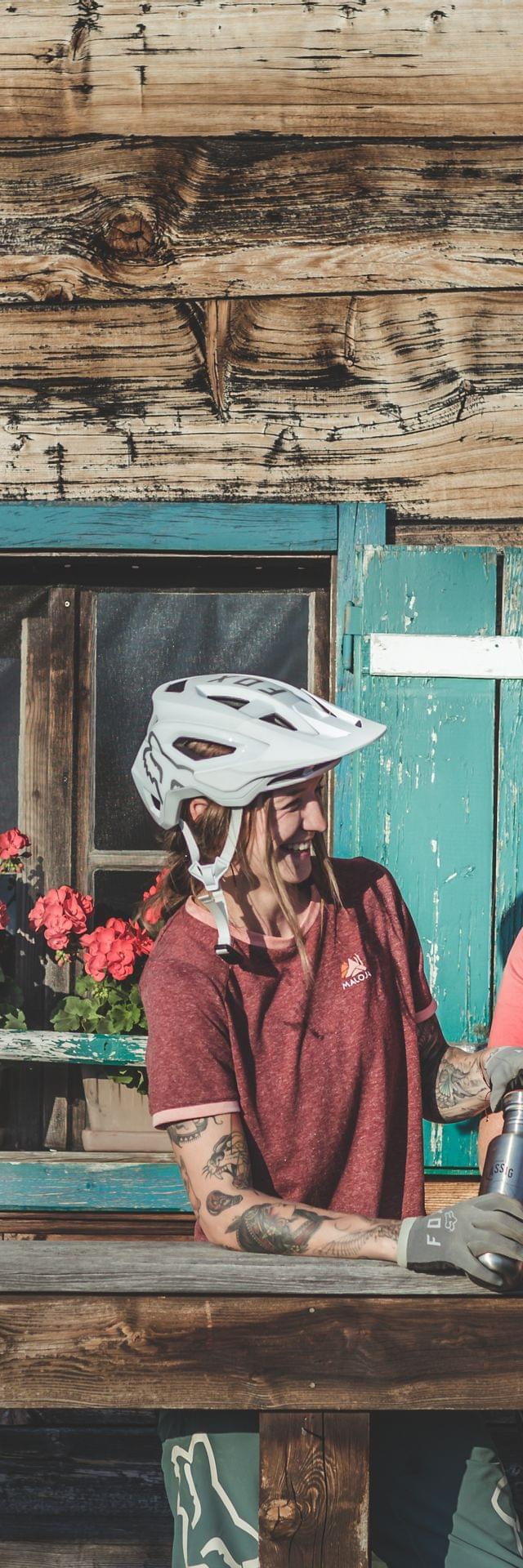 3 Frauen mit Radhelm auf vor einer Almhütte 