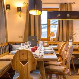 Gemütlicher Alpen-Restaurantbereich mit Holzmöbeln und gedecktem Tisch für Gäste