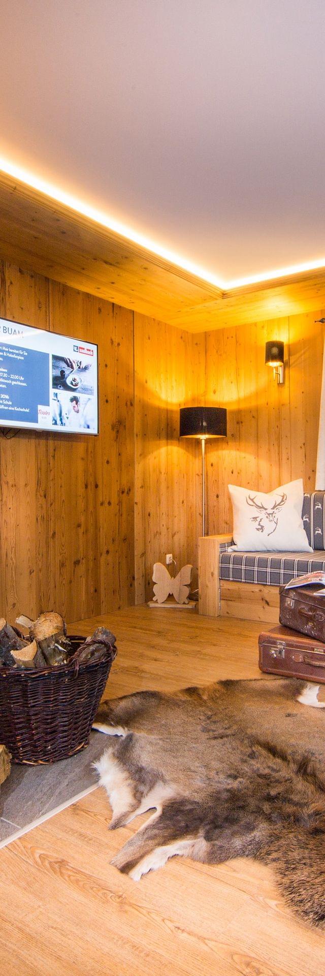 Gemütliches Wohnzimmer im Alpenstil mit Kamin, Holzverkleidung und rustikaler Einrichtung