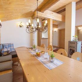 Cozy alpine dining room with wooden furniture, chandelier lighting and rustic decor