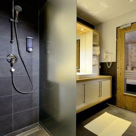 Modernes Badezimmer mit begehbarer Dusche und Holzsauna
